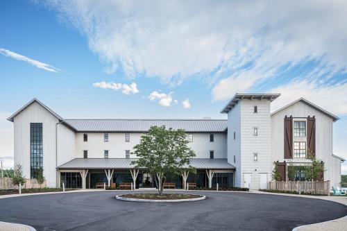 a large white building with a tree in front of it at Delamar Mystic in Mystic