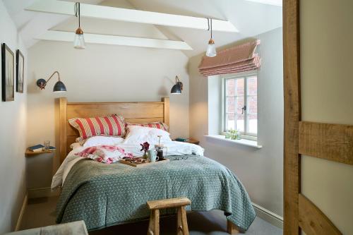 a bedroom with a bed with a green blanket at Courtyard Cottages Lymington, 2 Adults only in Lymington