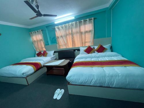 a bedroom with two beds and a couch and a fan at Parbat unique guest house in Kathmandu