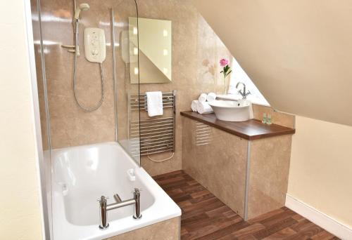 a bathroom with a sink and a bath tub at The Royal Hotel Cromarty in Cromarty