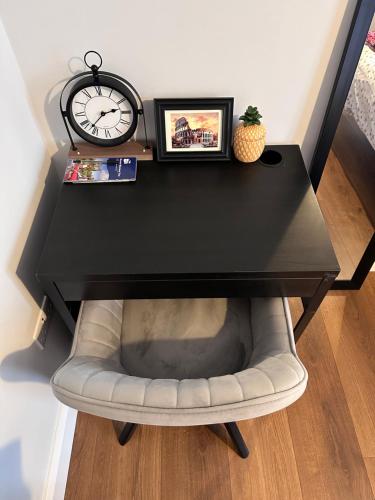 a black desk with a chair under a clock at Home sweet home in Drogheda