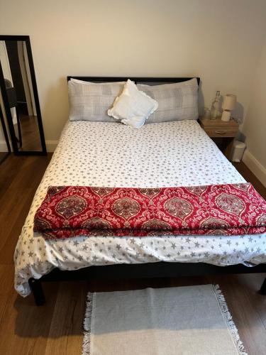 a bed with a red and white quilt on it at Home sweet home in Drogheda