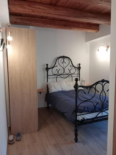 a bedroom with a black bed and a wooden floor at Rifugio Combe D'Imbert Vittoria in Champ Quartier