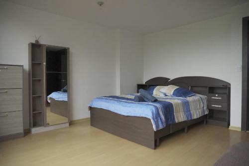 a bedroom with a bed and a dresser and a mirror at Casa Calma in Quito