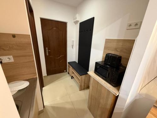 a small bathroom with a toilet and a microwave at SECRETO Apartman 1 in Komárno