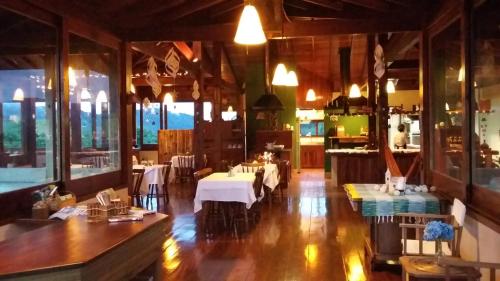 - un restaurant avec des tables et des chaises dans une salle dans l'établissement Pousada Bicho do Mato, à Gonçalves