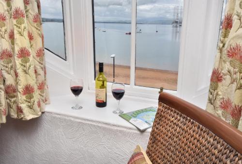 a table with two glasses of wine and a bottle at The Royal Hotel Cromarty in Cromarty