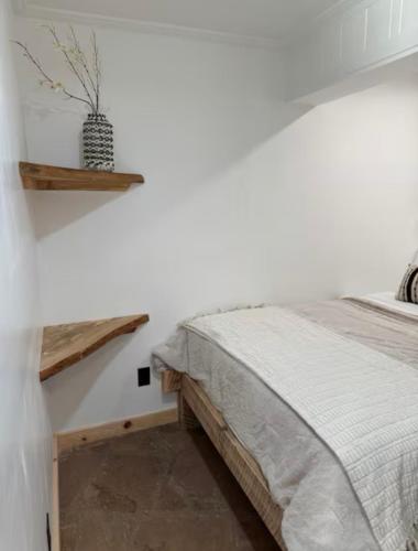 a bedroom with a bed and a shelf on the wall at oak&stone in Dalton