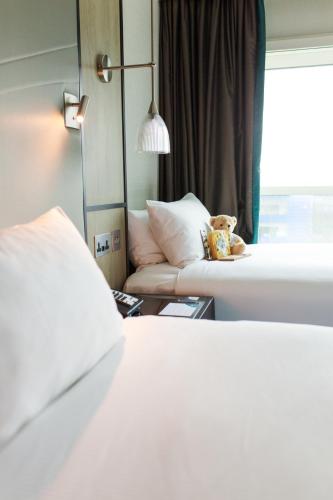 a hotel room with a bed and a couch at Hyatt Place London Heathrow Airport in Hillingdon