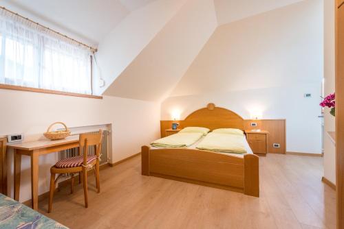 a bedroom with a bed and a table and a desk at Vogelmaierhof am Kalterer See in Caldaro