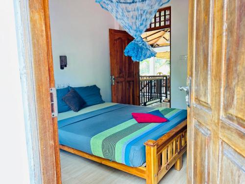 a bedroom with a bed with a door open at Pearl Bungalow Trincomalee in Trincomalee