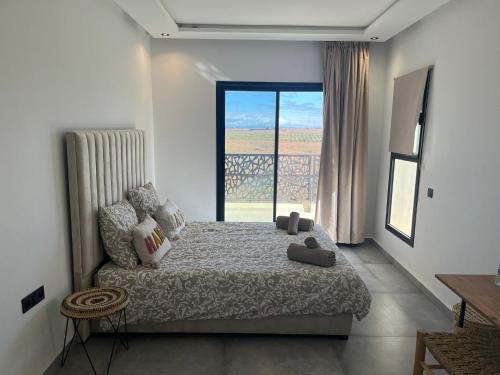 a bedroom with a bed and a large window at Luxury Villa Lam atlas view in Marrakesh