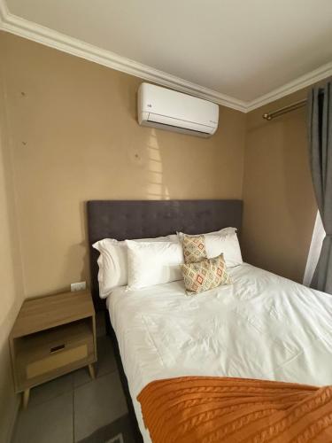 a bed with white sheets and pillows in a bedroom at Tshiamo Estate in Kuruman