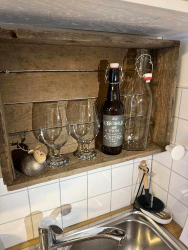 a kitchen sink with glasses and a bottle of wine at Hammergaarden - Kårstua - Panoramic Arctic Stay in Sortland