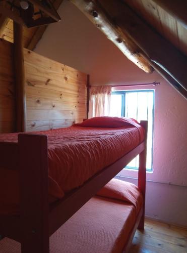 a bedroom with a bunk bed with a window at CABAÑAS L y L in Villa Santa Cruz del Lago