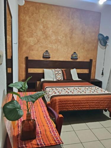a bedroom with two beds and a table with a plant at Hotel Kali Huasteca in Ciudad Valles