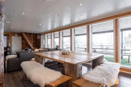 a living room with a wooden table and chairs at Villa West Ellivuori - High Quality 6BR Villa with Jacuzzi in Sastamala