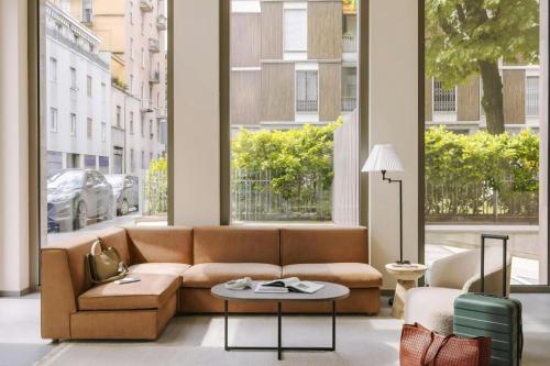 a living room with a couch and a large window at Numa Milan Montenero in Milan