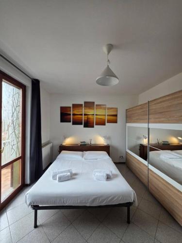 a large bedroom with two beds and a window at Easy Albese Comfort in Albese Con Cassano