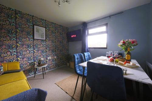 a dining room with a table and blue chairs at Thorpe Park Lodge - Ground Floor Detached & 2 Free Gated Parking Spaces in Thorpe