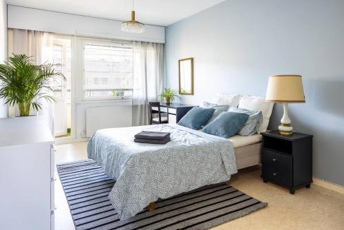 a bedroom with a bed and a lamp on a table at Borg Isolinna, Spacious 2-Room Apt For 4, Free Parking in Pori