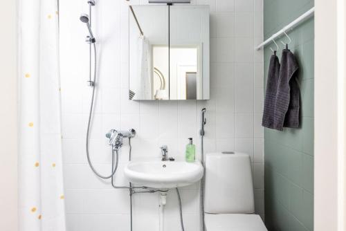 a white bathroom with a sink and a shower at Borg Isolinna, Spacious 2-Room Apt For 4, Free Parking in Pori