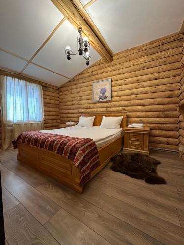 a bedroom with a bed and a wooden wall at Chateau Qusar Hotel & Restaurant in Qusar
