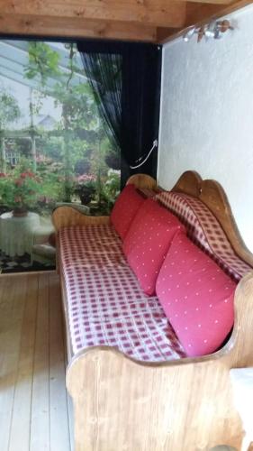 1 cama con almohadas rosas en una habitación con ventana en Chalet L'ourson en Chamonix-Mont-Blanc