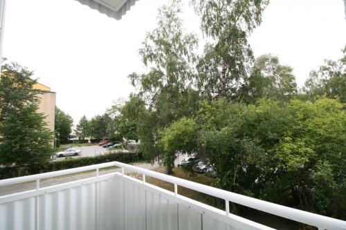 a balcony with a white fence and trees at Borg Kiertokatu, Spacious Studio Apt, Free Parking in Pori