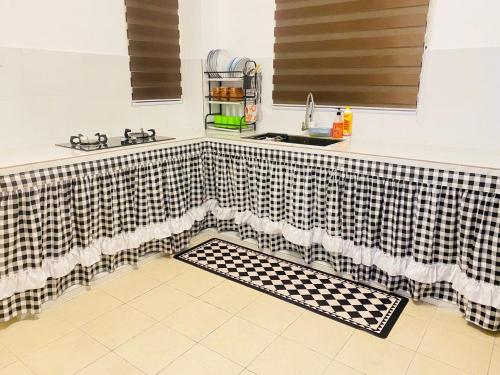 a kitchen with a black and white checkered curtain at HomestayBondaFaiiha in Port Dickson