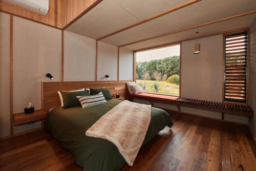 a bedroom with a large bed and a large window at Ellas Rest in Torquay