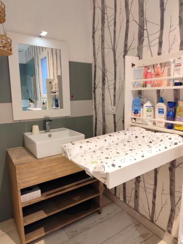 a bathroom with a sink and a mirror at Villa L'Echappée Oléronaise in Saint-Georges-dʼOléron