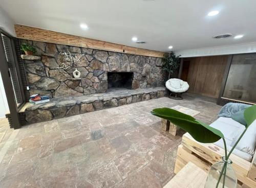 a living room with a stone wall with a fireplace at oak&stone in Dalton