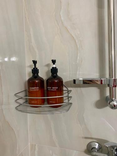 two soap dispensers sitting on a shelf in a bathroom at Lemon Luxury Studio in Xanthi