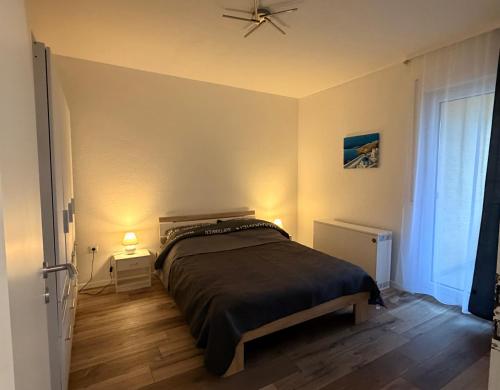 a bedroom with a bed and a ceiling fan at Modern 2-Room Apartment with Free Parking and Balcony in Waldmohr