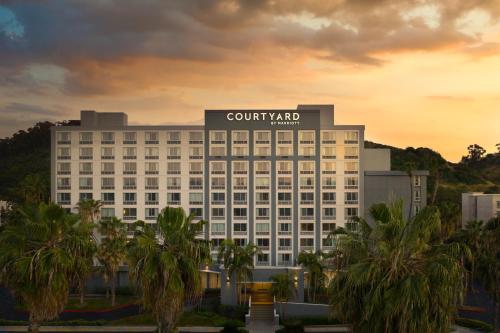 a view of a hotel with palm trees in front at Courtyard by Marriott San Diego Mission Valley/Hotel Circle in San Diego