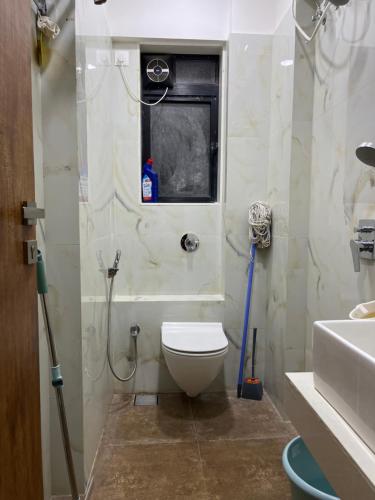a bathroom with a toilet and a window and a sink at Sumeru in Mumbai