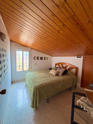 ein Schlafzimmer mit einem Bett und einer Holzdecke in der Unterkunft Caelum in Riumar