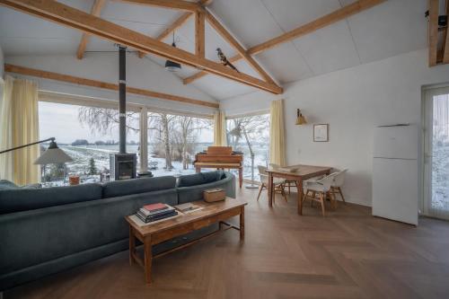a living room with a blue couch and a table at Beautiful Countryside house, close to Amsterdam in Broek in Waterland