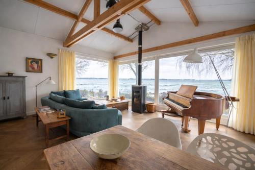 a living room with a table and a piano at Beautiful Countryside house, close to Amsterdam in Broek in Waterland