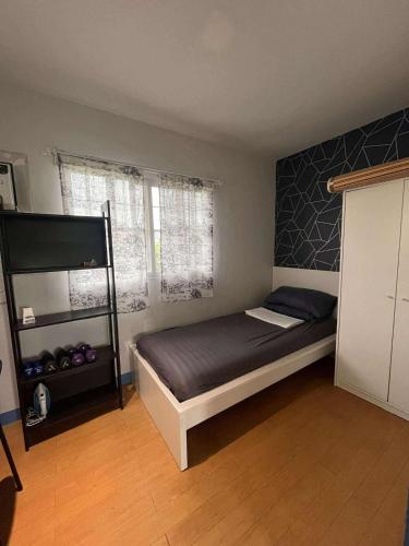 a bedroom with a bed and a shelf in a room at Modern 2 Storey 2BR Home with 2 Parking Space in Manila