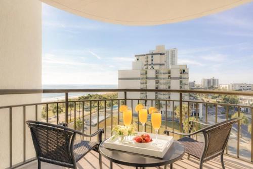 a balcony with a table and chairs and a view at Oceanview King Suite @ Meridian Plaza by Wavecrest Beach Vacations in Myrtle Beach