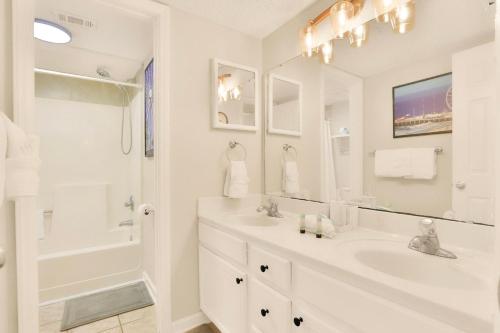 a white bathroom with a sink and a shower at Oceanview King Suite @ Meridian Plaza by Wavecrest Beach Vacations in Myrtle Beach