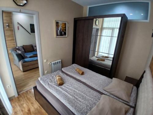 una piccola camera da letto con un letto e uno specchio di МАТЕ Apartment a Batumi