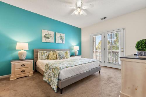a bedroom with a bed and a blue wall at Charming 3-Bedroom Cherry Grove Condo in Myrtle Beach