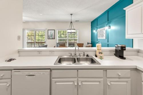 a kitchen with a sink and blue cabinets at Charming 3-Bedroom Cherry Grove Condo in Myrtle Beach