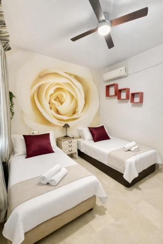 a bedroom with two beds and a ceiling fan at Sonia Home in Córdoba