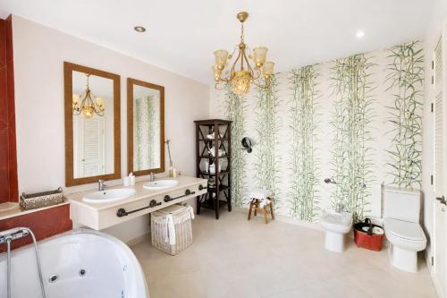a bathroom with two sinks and a tub and a toilet at Sonia Home in Córdoba