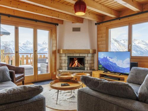 a living room with a fireplace and a television at Chalet La Balance by Interhome in Nendaz