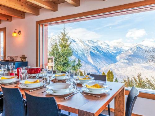 a dining table with a view of mountains at Chalet La Balance by Interhome in Nendaz